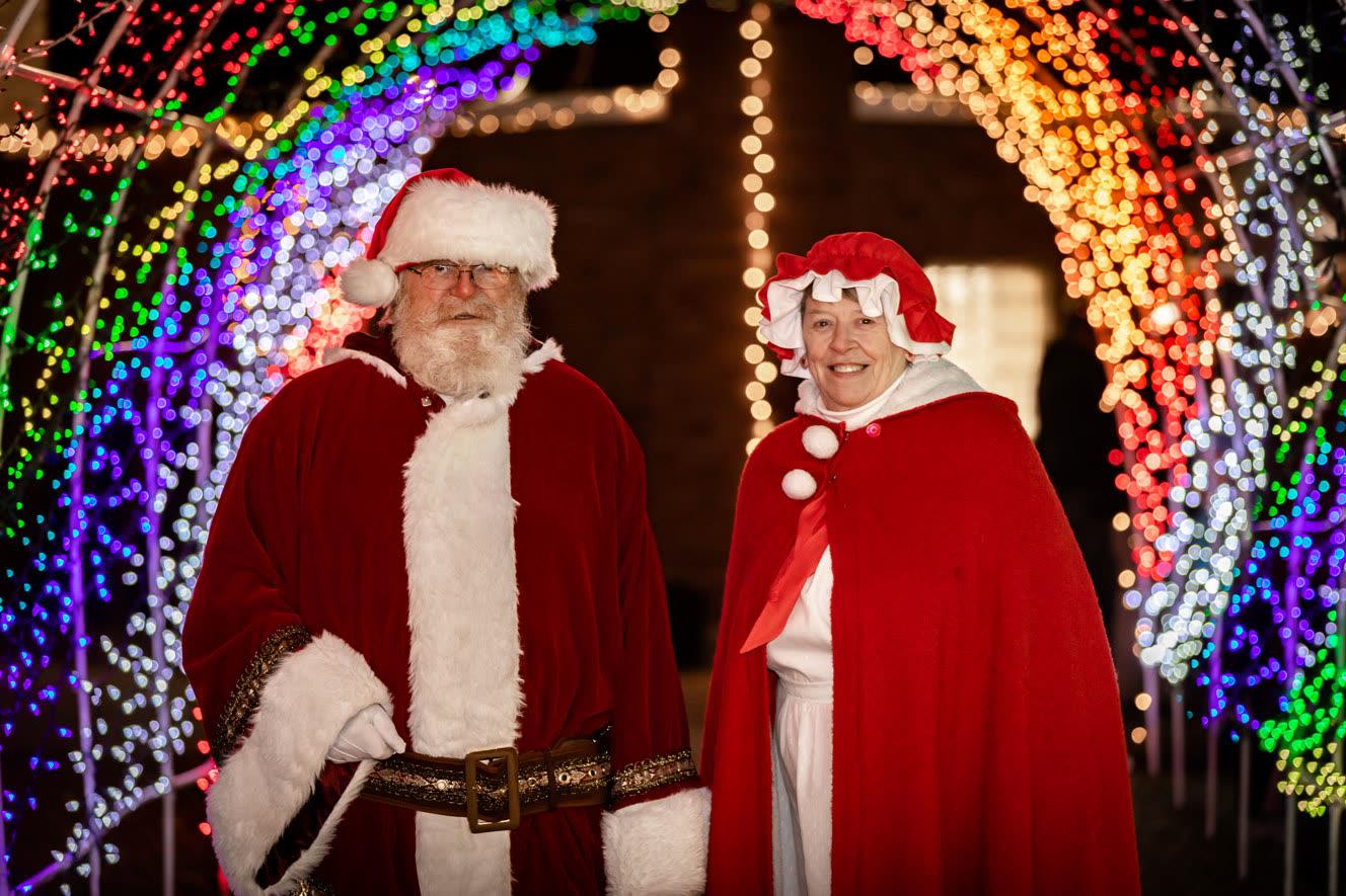 Santa and Mrs. Claus standing in the entrance of the light tunnel.